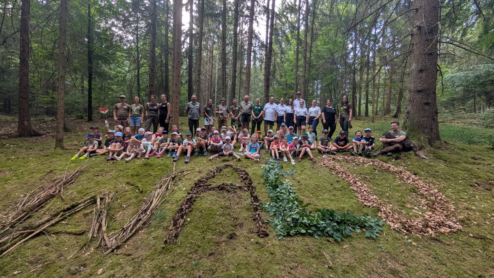 Kinder und Ehrenamtliche bei einer Naturaktion im Wald